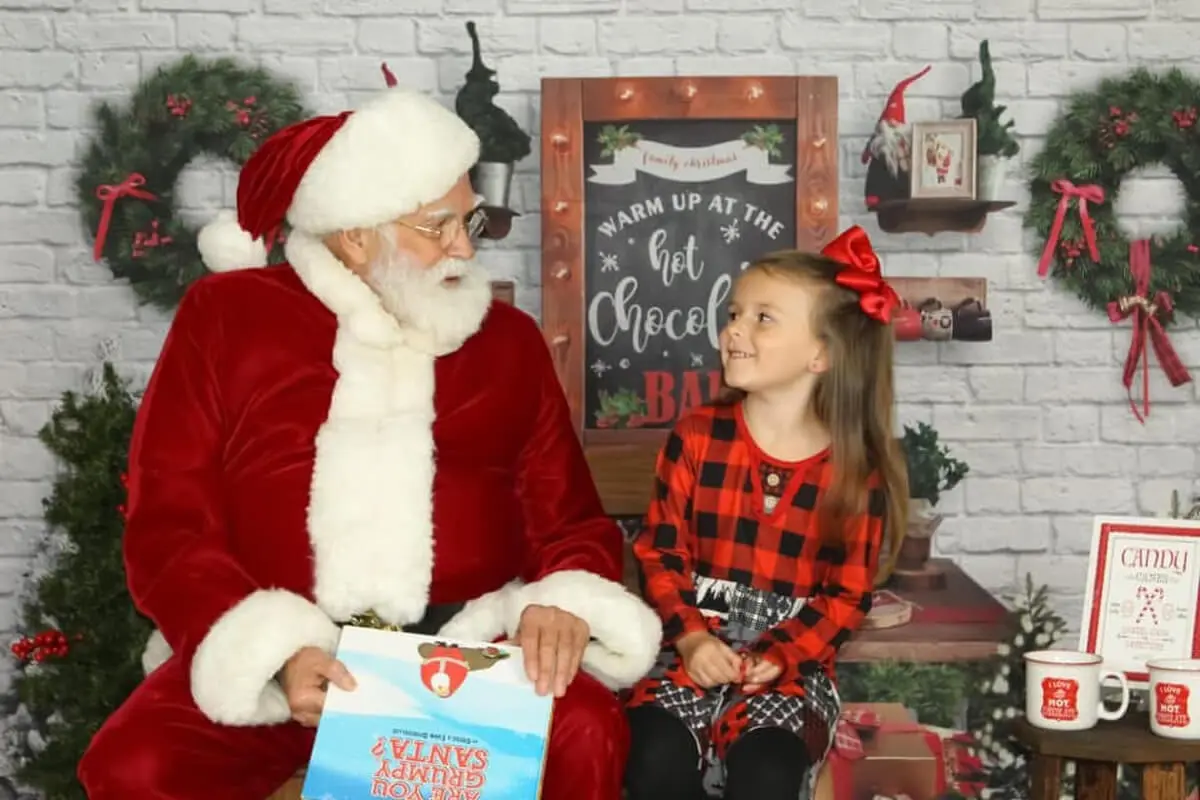 Santa talking to a smiling young girl.