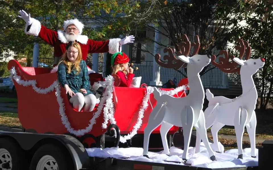 Santa and children on festive holiday float.