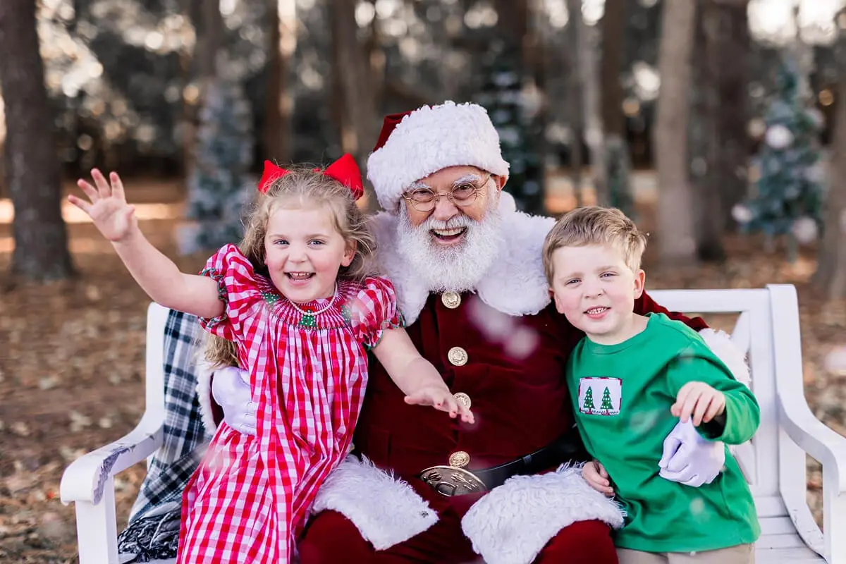 Santa with two happy children outdoors.