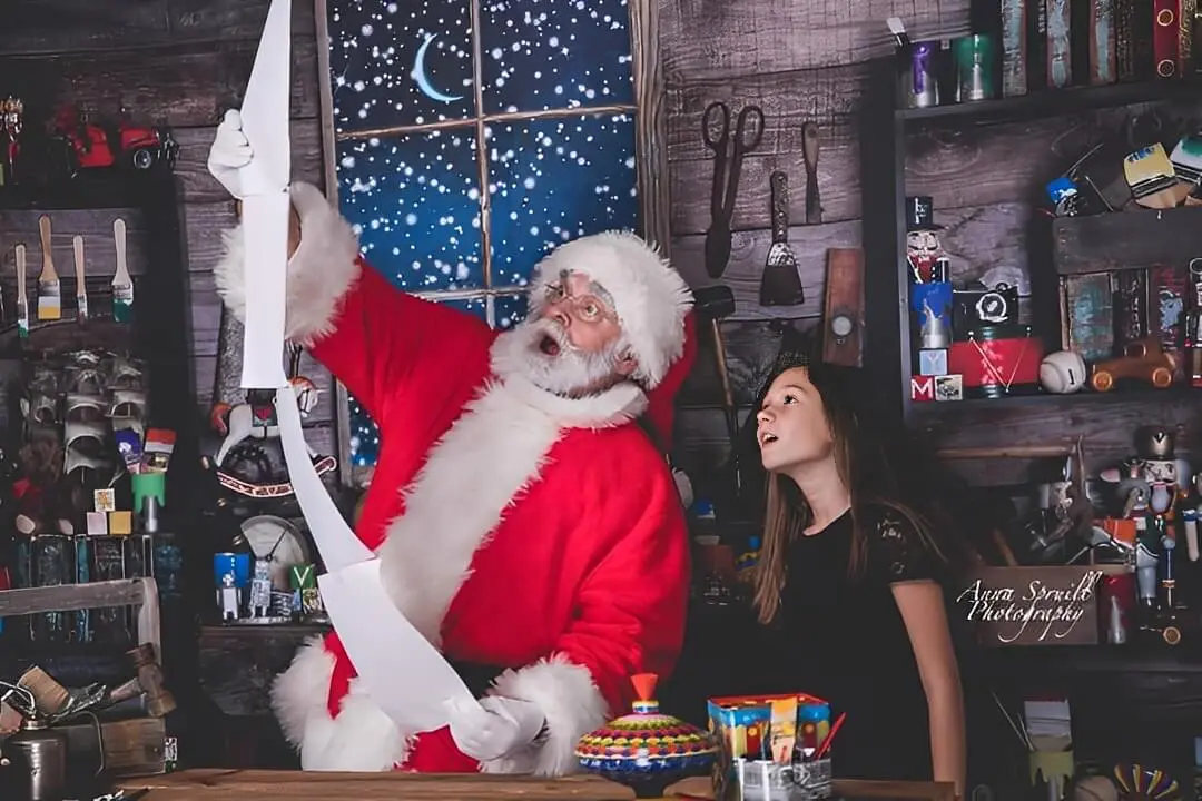 Santa and girl reading a long list.
