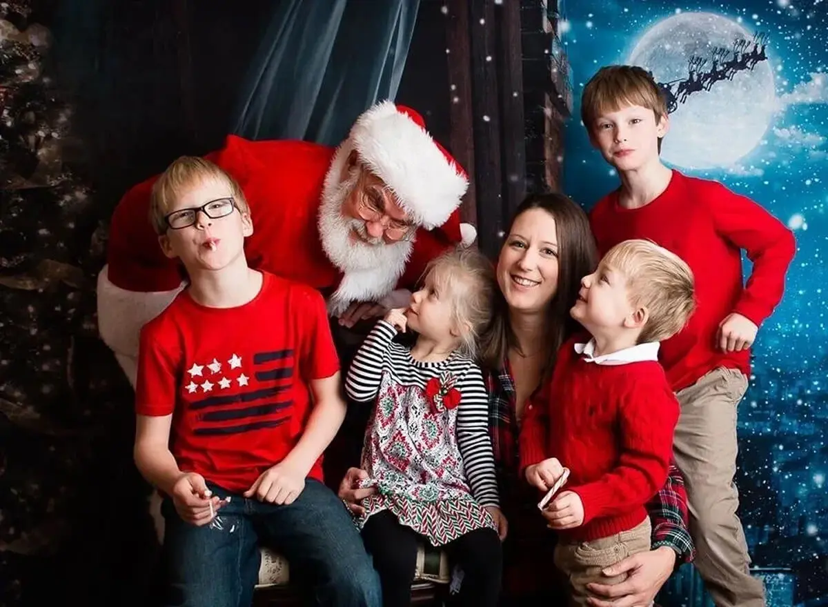 Family posing with Santa in festive setting.